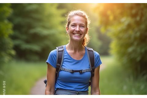 A smiling woman, Susan, in her late 50s, outdoors, looking active and happy.